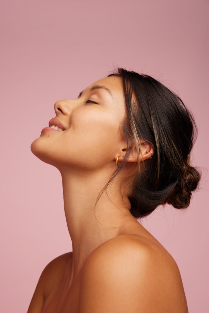 Happy young woman with healthy, glowing skin free from acne and blemishes